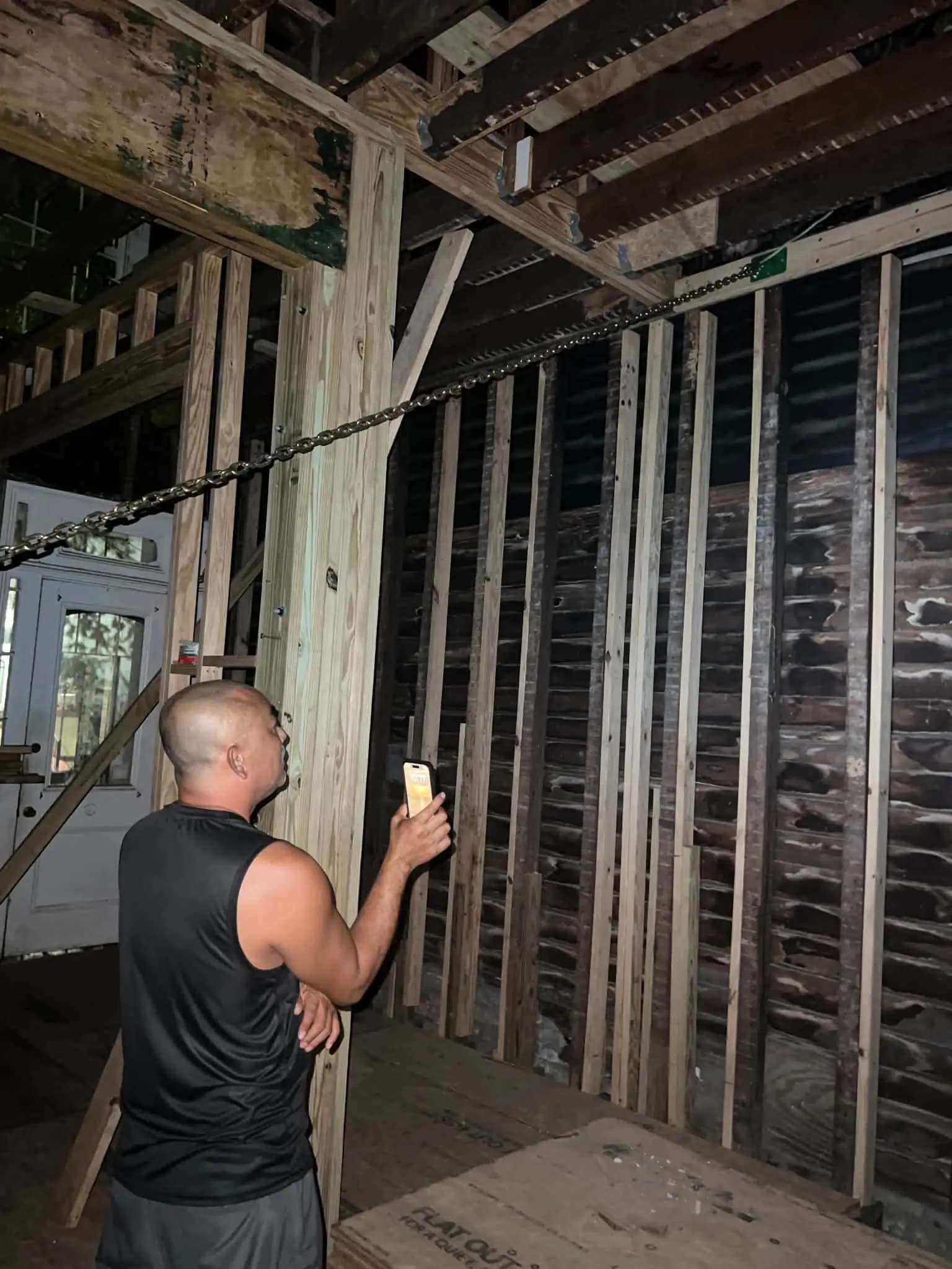 Person documenting exposed interior wall framing